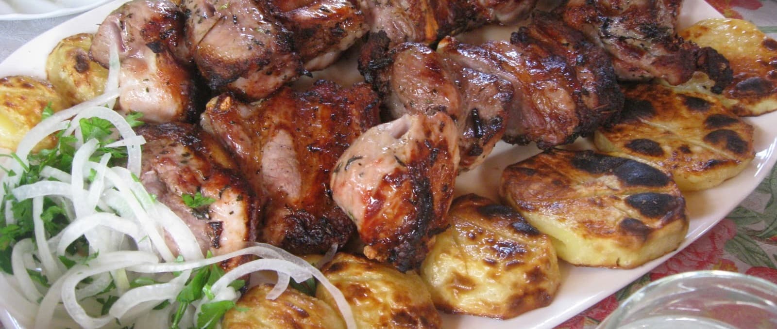 Skewers of khorovats grilling over an open wood fire