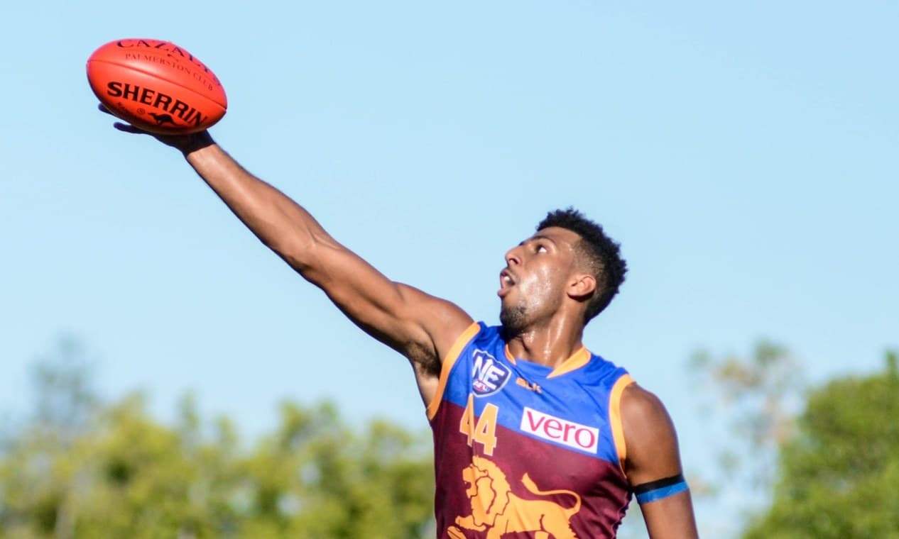 An AFL player leaping high to take a 'mark' over another player