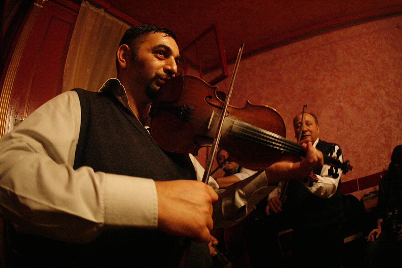 A Moldovan musician singing a doina in traditional costume in an outdoor setting