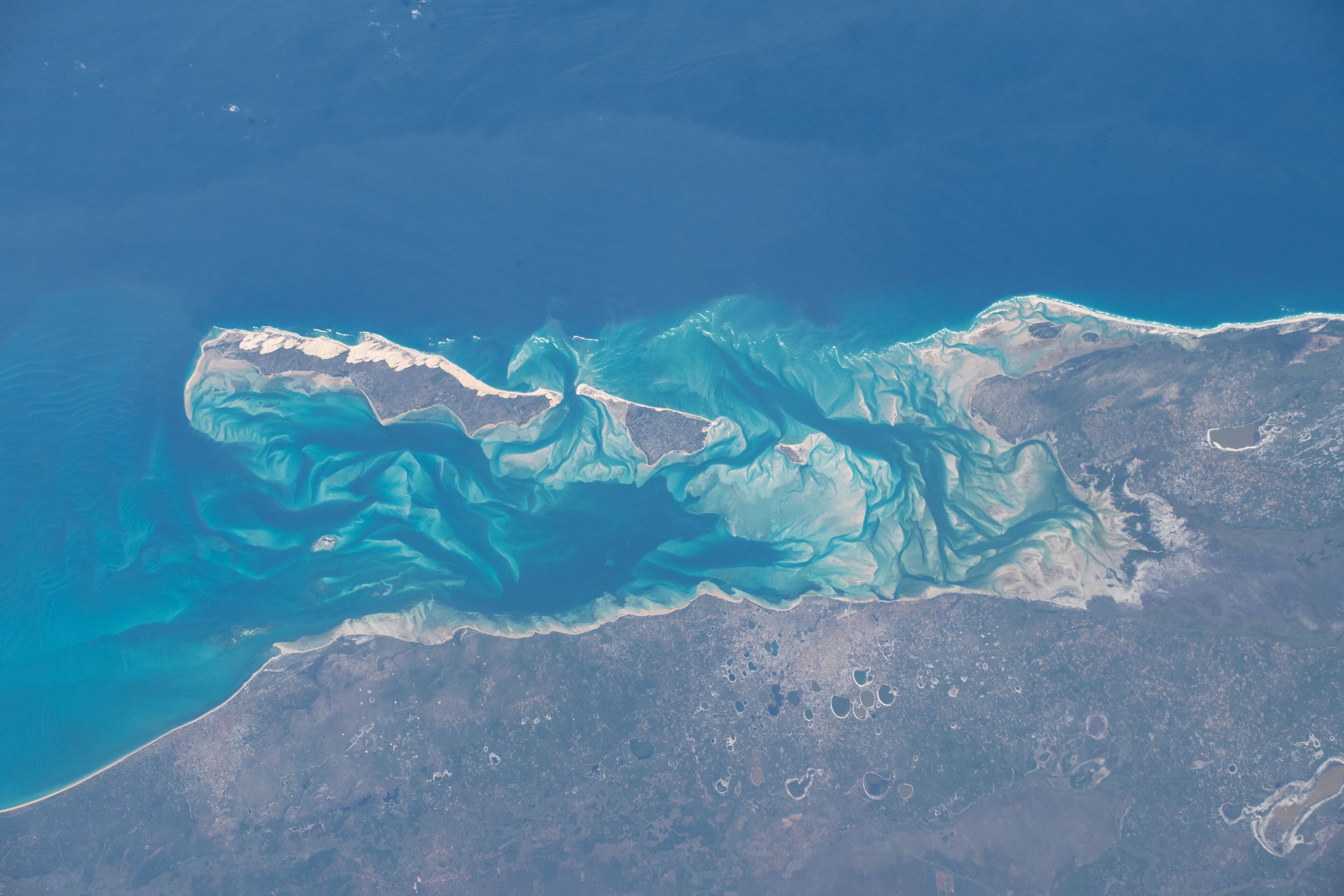 Crystal-clear turquoise water surrounding a white sand island in the Bazaruto Archipelago