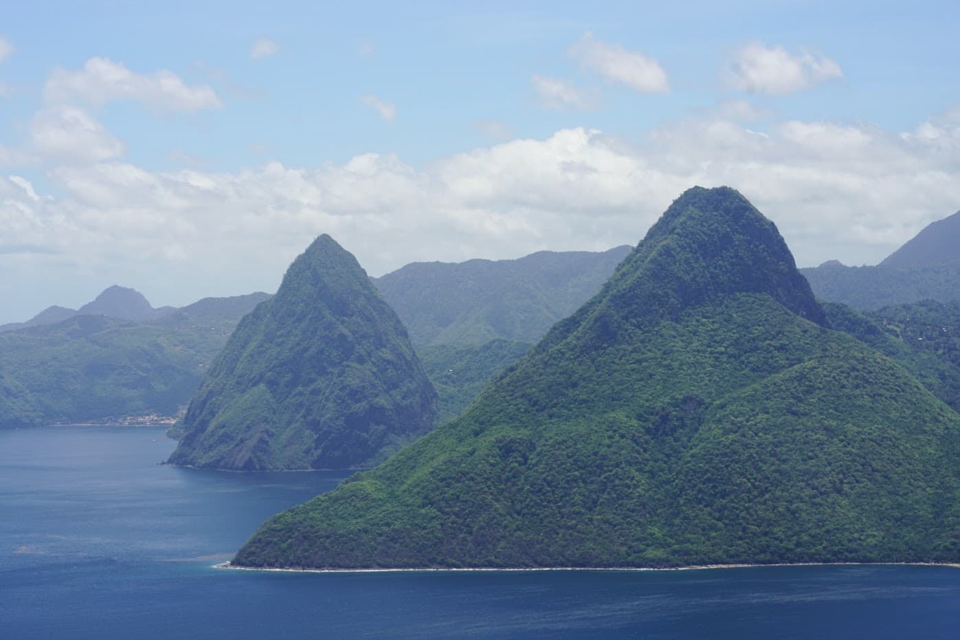 Two dramatic green peaks, the Pitons, rising sharply from the Caribbean Sea