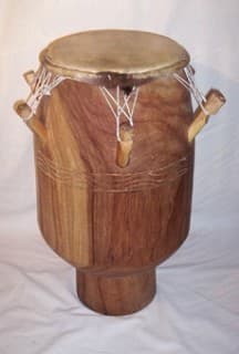 Ewe drummers in traditional white cloth playing at an outdoor ceremony